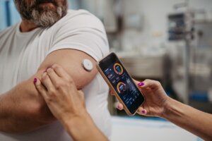 Osoba monitorująca za pomocą telefonu stan cukrzycy u drugiej osoby